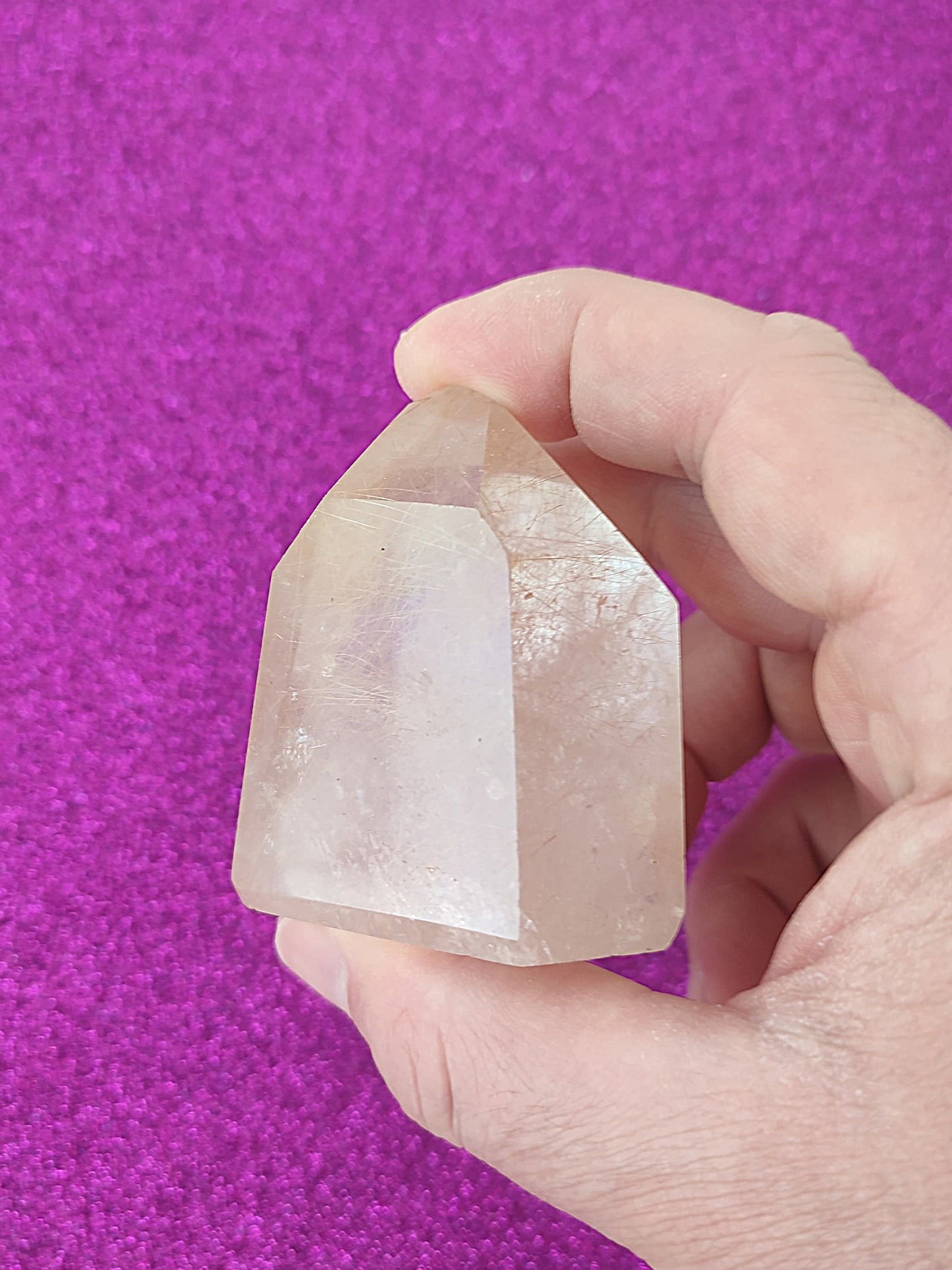 Cuarzo con inclusiones de rutilo y hematite rojo - Primer plano de cuarzo cristal rutilado, con trazas doradas y rojizas de hematite.