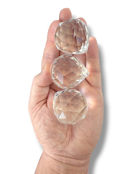 Tres bolas Feng Shui de 40 mm en una mano sobre fondo blanco