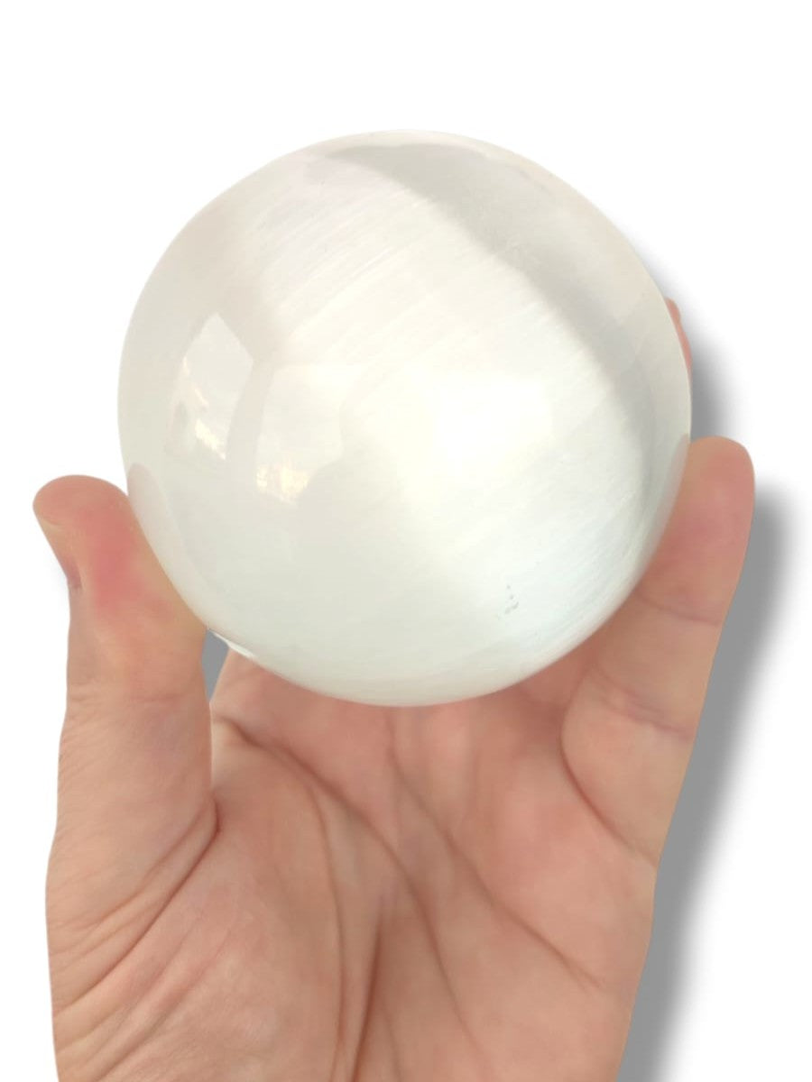 esfera grande de selenita natural sobre fondo blanco