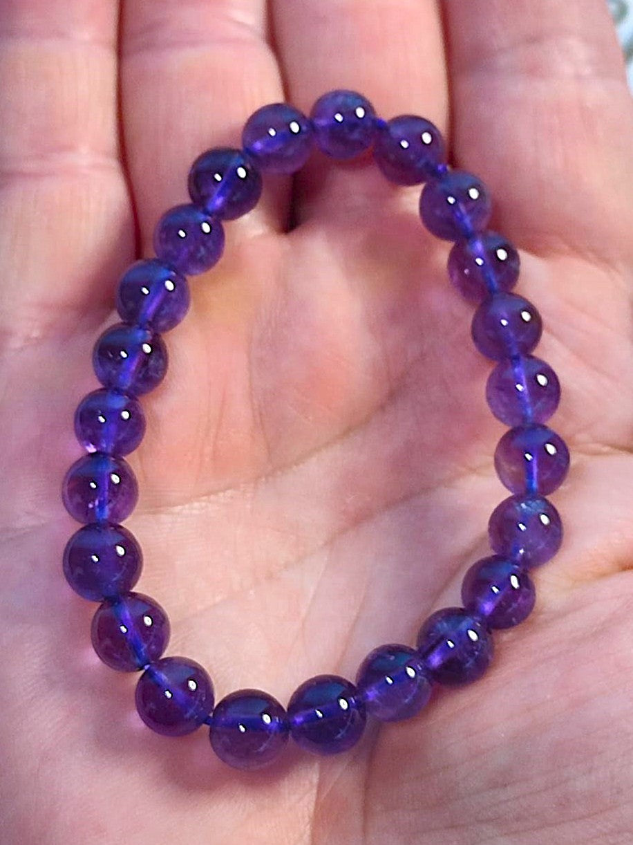 Pulsera de amatista natural con cuentas de 8 mm en tonos púrpuras profundos, ideal para meditaciones y protección espiritual